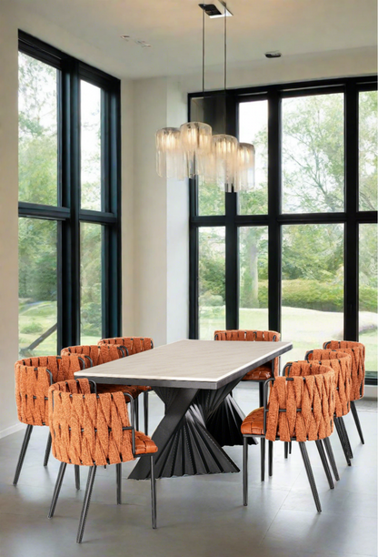 Black and white marble top rectangular modern dining table with 8 orange curved faux leather dining chairs in orange and black